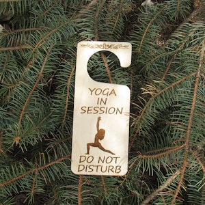 May include: Wooden door hanger with the text "Yoga in Session - Do Not Disturb" and a silhouette of a person in a yoga pose.