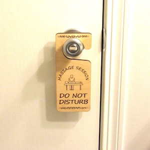 May include: A wooden door hanger with the text "Massage Session Do Not Disturb" and a silhouette of a person receiving a massage.