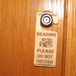 May include: Wooden door hanger with the text "Reading Please Do Not Disturb" and a stack of books illustration.