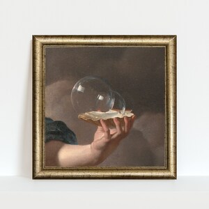 May include: A framed painting of a hand holding a seashell with two glass bubbles inside. The bubbles are transparent and reflect light. The hand is painted in a realistic style, and the background is a dark brown.