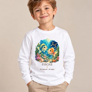 Junge trägt Kinder-Langarmshirt mit Fische-Motiv aus „Deine kleine Sternenwelt“ (Bild mit KI erstellt)
