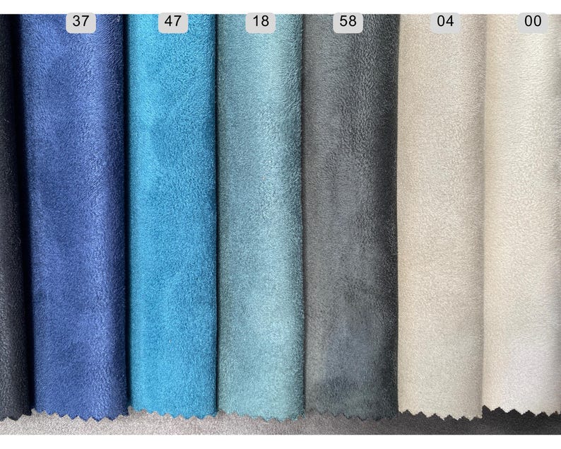 May include: A collection of fabric swatches in various shades of blue, gray, and beige. The swatches are arranged vertically, showcasing a range of colors from deep navy to light cream. Each swatch is labeled with a number.