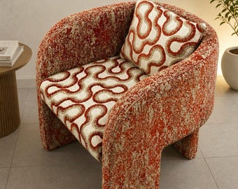 May include: A barrel-style armchair upholstered in a textured, burnt orange and cream bouclé fabric. The seat and the included square throw pillow feature a repeating wavy, organic line pattern in shades of rust, brown, and off-white.
