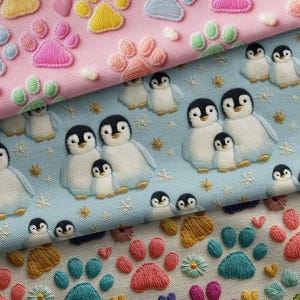 May include: Close-up of three fabrics with embroidered patterns. The top fabric is pink with yellow, pink, and blue paw prints. The middle fabric is light blue with penguin families. The bottom fabric is gray with colorful paw prints, hearts, and flowers.