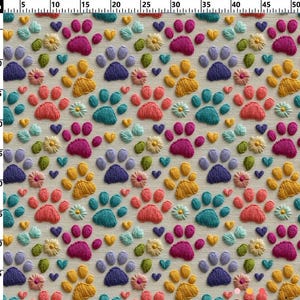 May include: A fabric with a repeating pattern of embroidered paw prints, hearts, and flowers in various colors. The paw prints are in shades of orange, pink, blue, and purple. The flowers are yellow and white, and the hearts are blue and yellow.