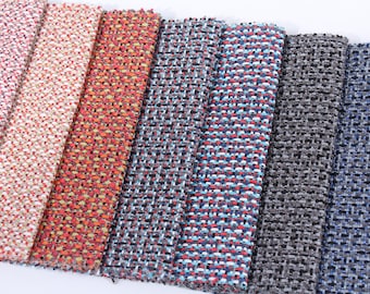 May include: Close-up of six fabric swatches in various colors and patterns. The swatches are arranged horizontally, with the lightest color on the left and the darkest color on the right. The swatches are all woven with a textured, tweed-like pattern.