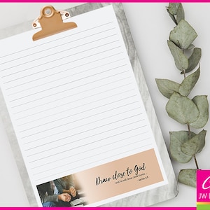 May include: A lined notepad with a clipboard and a quote that reads "Draw close to God and he will draw close to you... James 4:8". The notepad has a peach colored bottom with a couple holding hands in prayer.