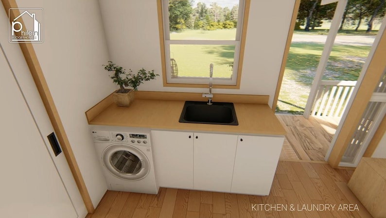 May include: Interior view of a kitchen and laundry area. Features a white washing machine, white cabinets, a black sink, and a wooden countertop. A small potted plant sits on the countertop. The room has a window and a door leading to an outdoor area.