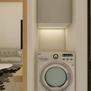 May include: Interior view of a modern home with a laundry area and a glimpse of a bathroom. The laundry area features a washing machine and a storage cabinet. A sofa, coffee table, and lamp are visible in the living area.