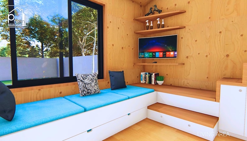 Puede incluir: Interior de una sala de estar moderna con un banco incorporado con cojines azules y cajones de almacenamiento blancos. Un televisor de pantalla plana est&aacute; montado en una pared con paneles de madera, con estantes flotantes arriba y abajo. Una gran ventana ofrece una vista del exterior.