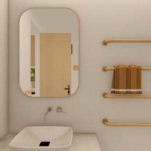 May include: A modern bathroom interior featuring a white sink, a large mirror, and gold-colored towel racks. Brown towels are neatly arranged on one of the racks. The wall is a neutral color, creating a clean and minimalist aesthetic.