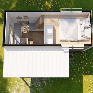 May include: An overhead view of a tiny house with a white exterior and a black roof. The interior features a bedroom with a bed, a kitchen area, and a living space. The house is surrounded by green grass and a few leaves.