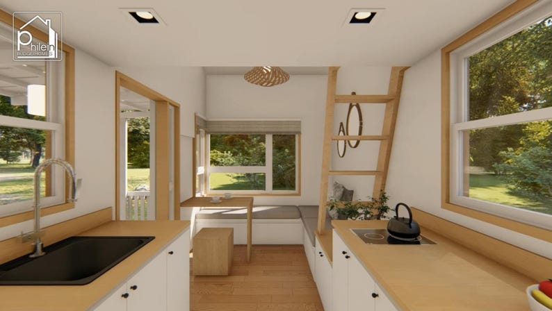 May include: Interior view of a tiny house kitchen with light wood cabinets and countertops. A black sink and stovetop are visible. A wooden ladder leads to a loft area. A window provides a view of the outdoors.