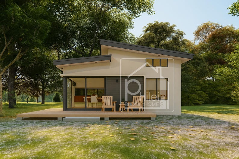 Puede incluir: Una casa moderna de una sola planta con un exterior claro y un tejado gris oscuro. La casa tiene grandes ventanas y una terraza de madera. Dos sillas de madera y una peque&ntilde;a mesa est&aacute;n en la terraza. La casa est&aacute; rodeada de &aacute;rboles y hierba.