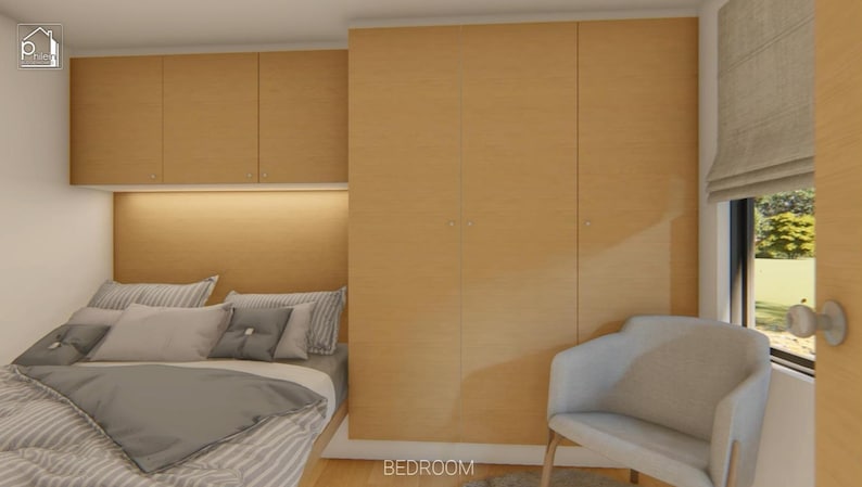 Puede incluir: Interior de dormitorio con armarios de madera clara y cabecero empotrado con un brillo c&aacute;lido. La cama est&aacute; hecha con ropa de cama gris y blanca, y una silla blanca est&aacute; cerca de una ventana con una persiana de tono neutro. La palabra "BEDROOM" es visible.