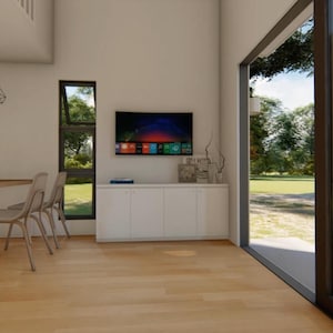 May include: Interior view of a modern living area with a dining table and chairs, a wall-mounted television, and a large window overlooking a green landscape. The room features light-colored wood flooring and white walls.