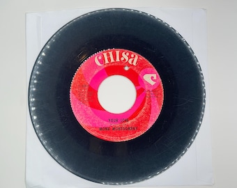 May include: A black vinyl record with a red and white label. The label says "Chisa" and "Your Love" by "Monk Montgomery".