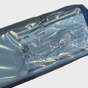 May include: A sealed Epson Matte Black T6368 ink cartridge in a clear plastic package. The package has printed text and warnings in multiple languages. The Epson logo is visible.