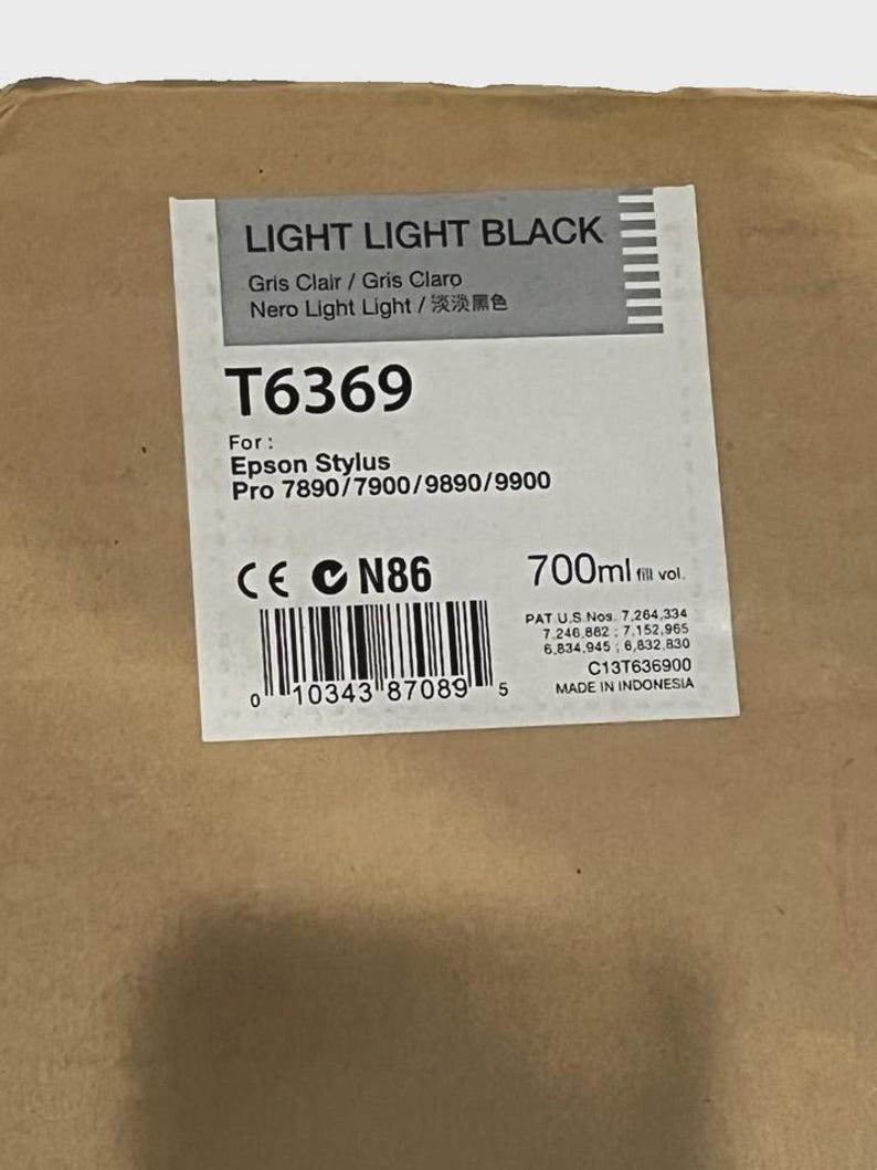 May include: A rectangular box with a label that reads "LIGHT LIGHT BLACK." The label includes the text "T6369" and "Epson Stylus Pro 7890/7900/9890/9900." It also indicates a volume of 700ml and is made in Indonesia.