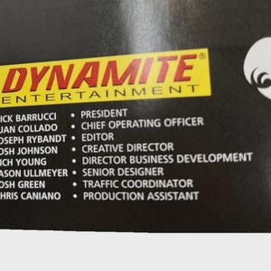 Może przedstawiać: Czarne tło z logo "DYNAMITE ENTERTAINMENT" w kolorze czerwonym i ż&oacute;łtym. Poniżej znajdują się nazwiska i stanowiska pracownik&oacute;w firmy, w tym Prezes, Dyrektor Operacyjny i Redaktor.