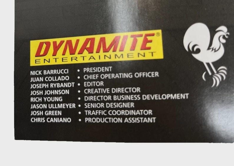 Może przedstawiać: Czarne tło z logo "DYNAMITE ENTERTAINMENT" w kolorze czerwonym i ż&oacute;łtym. Poniżej znajdują się nazwiska i stanowiska pracownik&oacute;w firmy, w tym Prezes, Dyrektor Operacyjny i Redaktor.