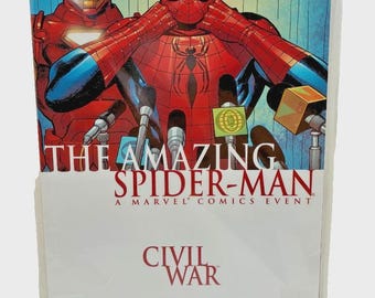 May include: A comic book titled The Amazing Spider-Man Civil War, a Marvel Comics event. The cover features Spider-Man and Iron Man standing behind microphones. The text reads The Amazing Spider-Man, A Marvel Comics Event, Civil War, Straczynski, Garney.