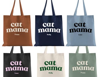 Può includere: Sei borse tote con il testo "cat mama" in diversi colori e font. Le borse sono marrone, blu navy, blu chiaro, nero, crema e verde salvia. Ogni borsa ha un nome stampato sotto il testo.