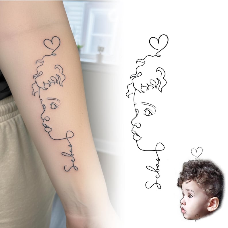 Fine line tattoo on arm next to original toddler photo. Custom tattoo design from photo and minimalist baby face tattoo commission.