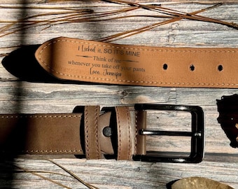 May include: A brown leather belt with a silver buckle. The belt has the text "I Licked it, SO IT'S MINE - Think of me whenever you take off your pants Love, Jennifer" engraved on it. The belt is approximately 1.5 inches wide.