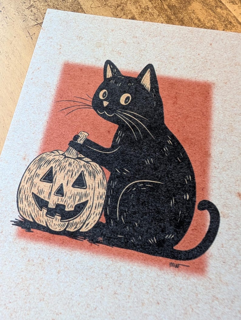 May include: A black cat illustration with a carved pumpkin. The cat is sitting next to the pumpkin, which has a smiling face. The background is a red square on a beige paper.
