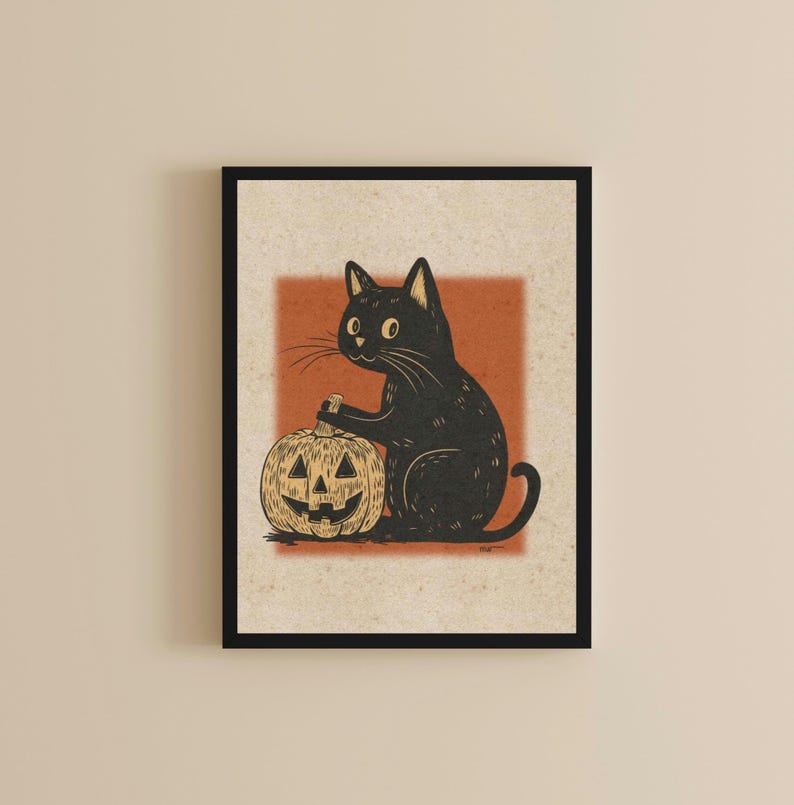 May include: A framed print featuring a black cat and a carved pumpkin. The cat is depicted with large eyes and is positioned next to the pumpkin. The pumpkin has a carved face. The background is a light beige with an orange square.