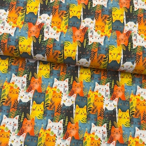 May include: A patterned fabric featuring a repeating design of cat faces in orange, yellow, white, and black. Green leaf shapes are between the cats on a blue backdrop. The material is likely cotton or a similar textile, suitable for various craft projects.