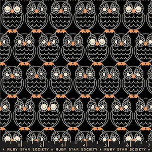 May include: Black fabric with a repeating pattern of white owls with orange beaks and feet. The owls have closed eyes and are outlined in white.