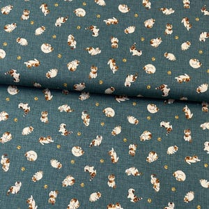 May include: Teal fabric featuring a repeating pattern of white and brown cats in different poses. Small yellow circles are scattered across the design. The fabric has a textured appearance.