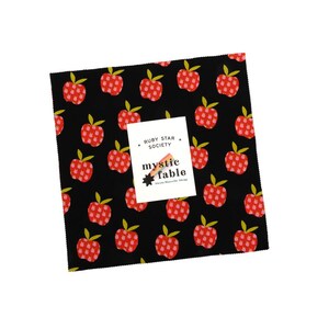 May include: A square fabric swatch featuring a black background with a repeating pattern of red apples with green leaves. A white rectangular label is centred on the fabric, printed with the text Ruby Star Society, mystic fable, and Alecia Marcelle Abegg.