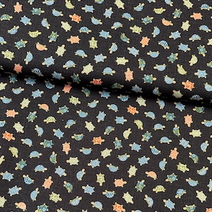May include: Dark navy fabric featuring a repeating pattern of turtles in various colours. The turtles are in shades of blue, green, orange, and peach. The fabric has a slightly textured appearance.