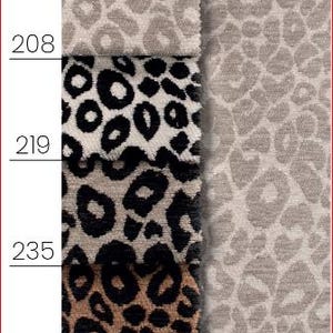 Könnte beinhalten: Eine vertikale Anordnung von acht Stoffmustern mit verschiedenen Leopardenmustern und einfarbigen Texturen. Jedes Muster ist mit den Nummern 222, 227, 208, 219, 235, 242, 216 und 218 gekennzeichnet und zeigt Farben von Creme und Beige bis hin zu Braun, Grau und Schwarz.