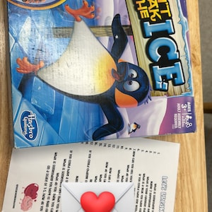 May include: A board game called "Don't Break the Ice" featuring a penguin on a blue and white ice background. The game is for ages 3 and up and requires adult assembly.