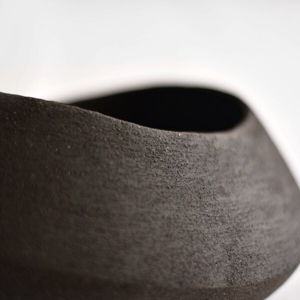 Minimalist stoneware ceramic vessel for interior design, Textured vase with curved lines for coffee table, Unglazed black decorative bowl