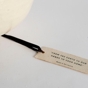 May include: A brown paper tag with the text "From the earth to our hands to your home." and "Made in Barcelona".