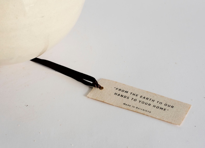May include: A brown paper tag with the text "From the earth to our hands to your home." and "Made in Barcelona".
