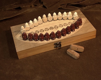 May include: A rectangular wooden game board featuring a central oval playing area with etched lines and circular markers. The board includes two sets of ten rounded game pieces in white and dark brown, plus two rectangular wooden dice with markings.