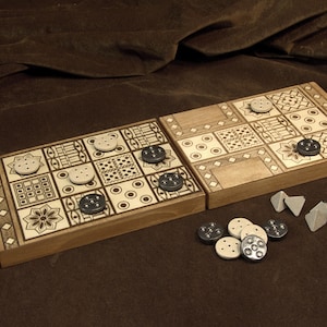 May include: A wooden board game with a decorative design, featuring a grid of squares with various patterns. The game includes light-colored and dark-colored game pieces. The board is set on a brown surface.