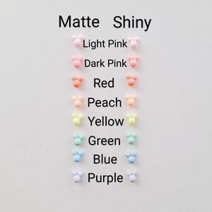 May include: A chart showing the color options for matte and shiny Mickey Mouse ears. The colors are light pink, dark pink, red, peach, yellow, green, blue, and purple.
