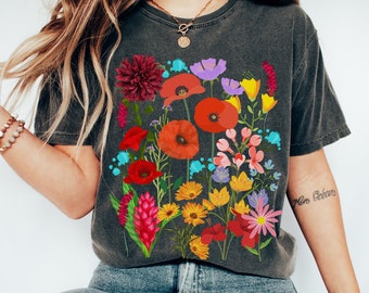 Może przedstawiać: Szary t-shirt z kolorowym nadrukiem kwiatowym z czerwonymi makami, różowymi, żółtymi i fioletowymi kwiatami. Nadruk jest umieszczony centralnie na koszulce i pokrywa większość przodu.