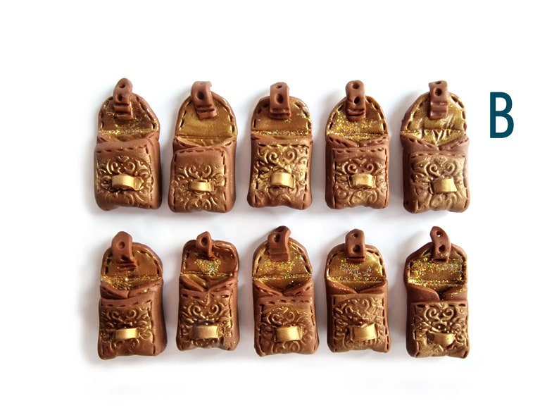 Op de afbeelding: Tien miniatuur bruine leren tassen met gouden accenten en glitter van binnen. De tassen zijn open en hebben een klep sluiting. De tassen zijn gerangschikt in twee rijen van vijf.