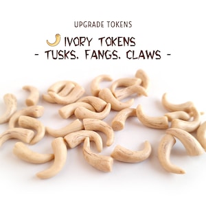 May include: A collection of 20 ivory-coloured plastic tokens shaped like tusks, fangs, and claws. The tokens are arranged in a pile on a white background. The text "IVORY TOKENS - TUSKS, FANGS, CLAWS -" is written above the tokens.