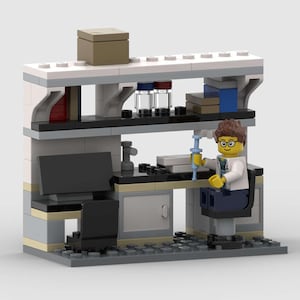 Puede incluir: Un set de laboratorio construido con bloques de plástico que incluye una minifigura de científico con gafas sosteniendo una jeringa azul. El puesto de trabajo incluye un escritorio negro, un monitor, estantes, viales de vidrio y una silla.
