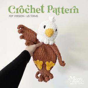 Pode incluir: Padrão de crochê para um brinquedo amigurumi de águia marrom e branco. A águia tem pés amarelos e um bico amarelo. O padrão está disponível em formato PDF e usa termos de crochê americanos. O padrão é de Merry Mac Hooks.