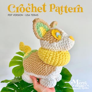 May include: A crochet pattern PDF version in USA terms featuring a plush toy of a four-legged creature with tan, white, and yellow yarn. The toy has large ears with green and yellow accents, a yellow neck ruff, and yellow felt eye details.
